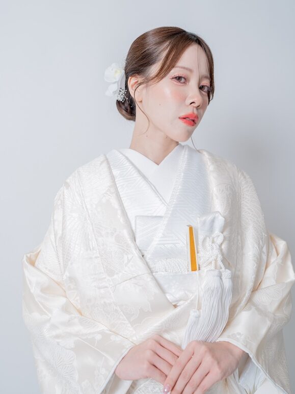 花の髪飾りを合わせ、柔らかいニュアンスでまとめた白無垢花嫁のクローズアップ
