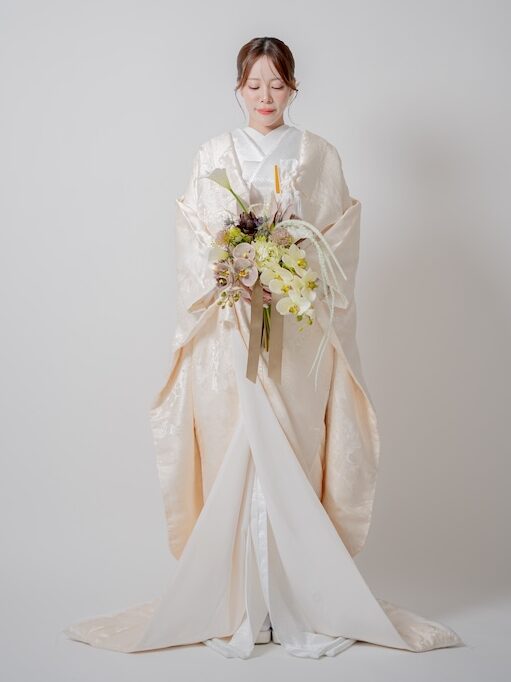 繊細な花や松の地紋が美しく浮かび上がるアイボリー白無垢のバックスタイル