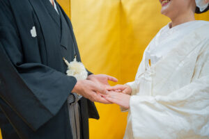 伝統的な和装をしたカップルが手をつなぐ様子を捉えた画像。