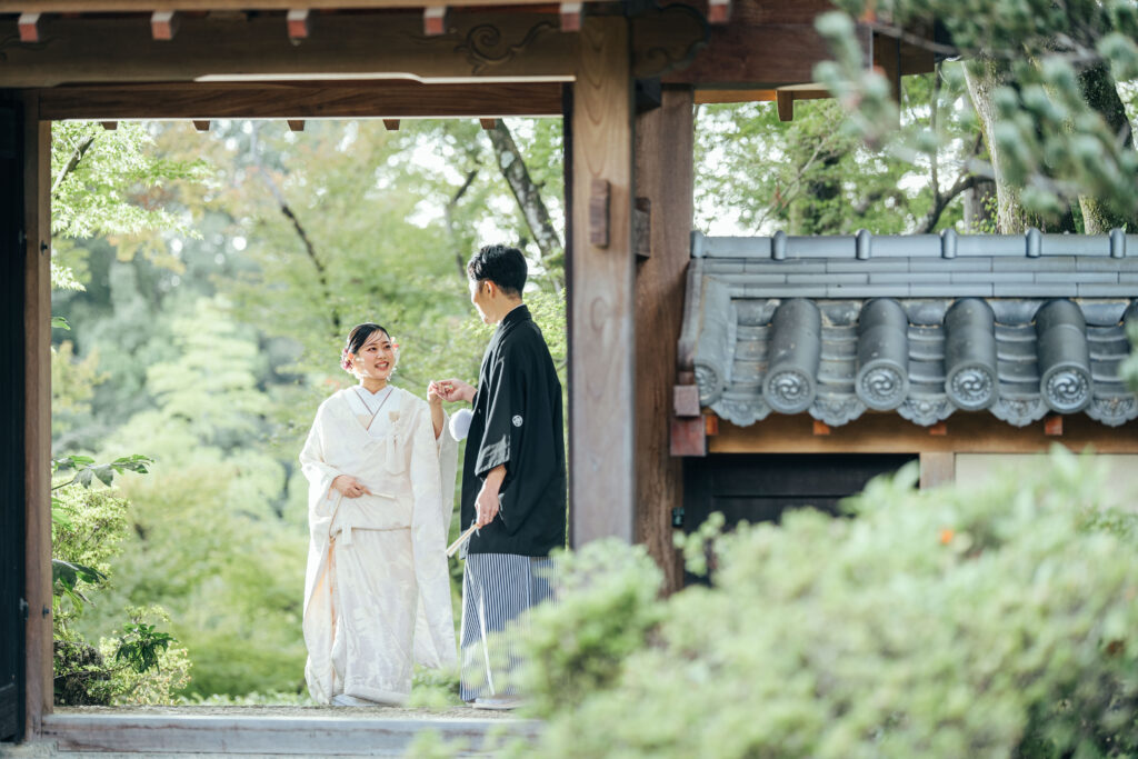 伝統的な和装を着たカップルが庭の入口で会話をしているシーン。