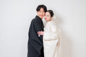 黒い和服を着た男性と白い和服を着た女性が寄り添っているポートレート写真