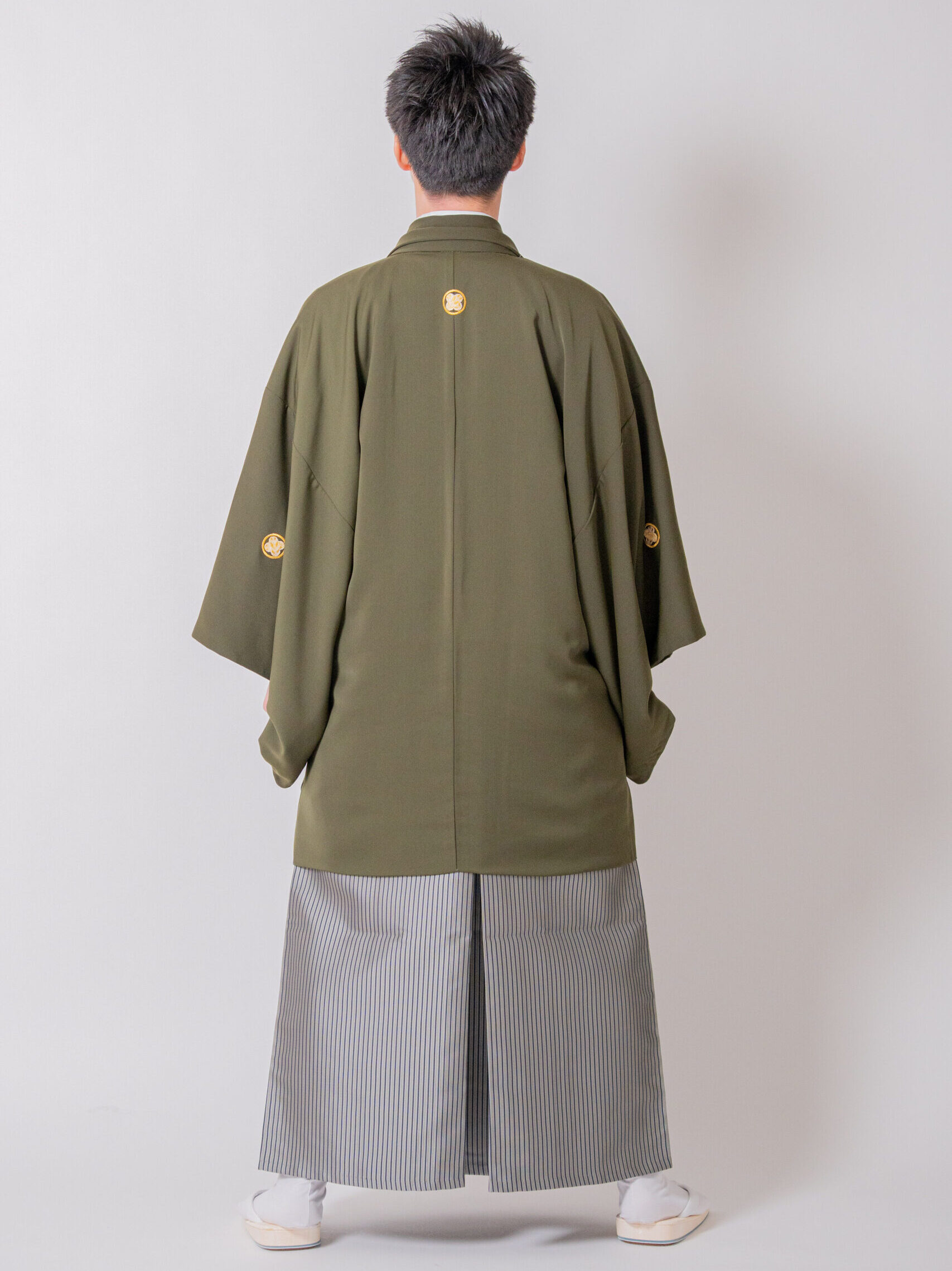 マットな陰影と野趣あふれる佇まいが際立つカーキ色紋付のバックスタイル（後ろ姿）