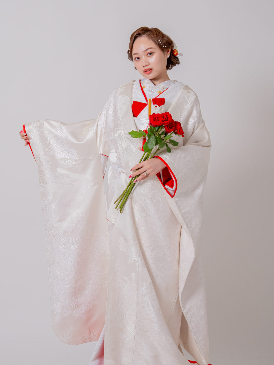 赤比翼の掛下と白無垢を組み合わせ、バラを持った個性あふれる花嫁スタイル