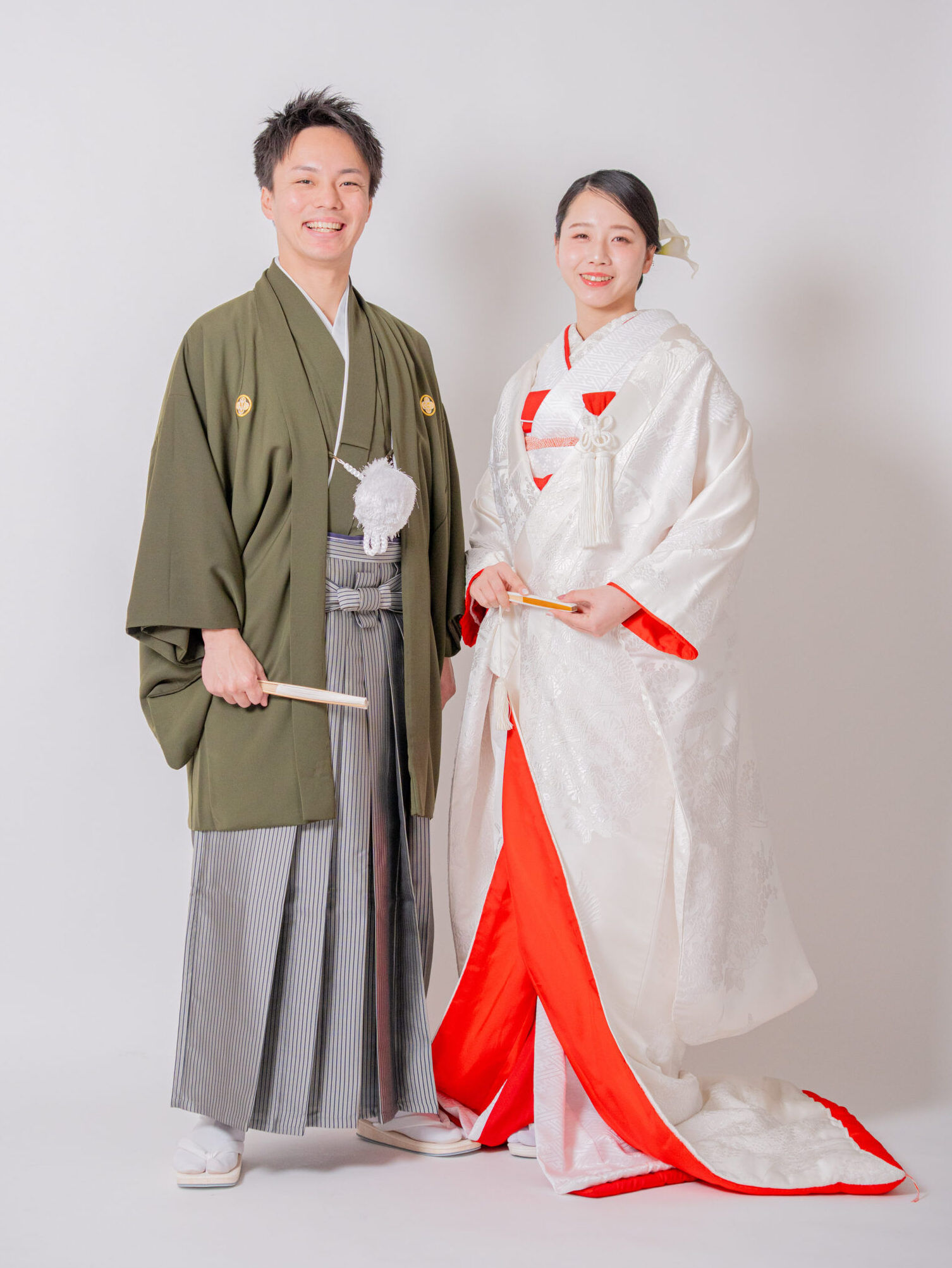 白無垢の花嫁とグリーンの色紋付を羽織る新郎が並ぶ、モダンな和装カップルショット
