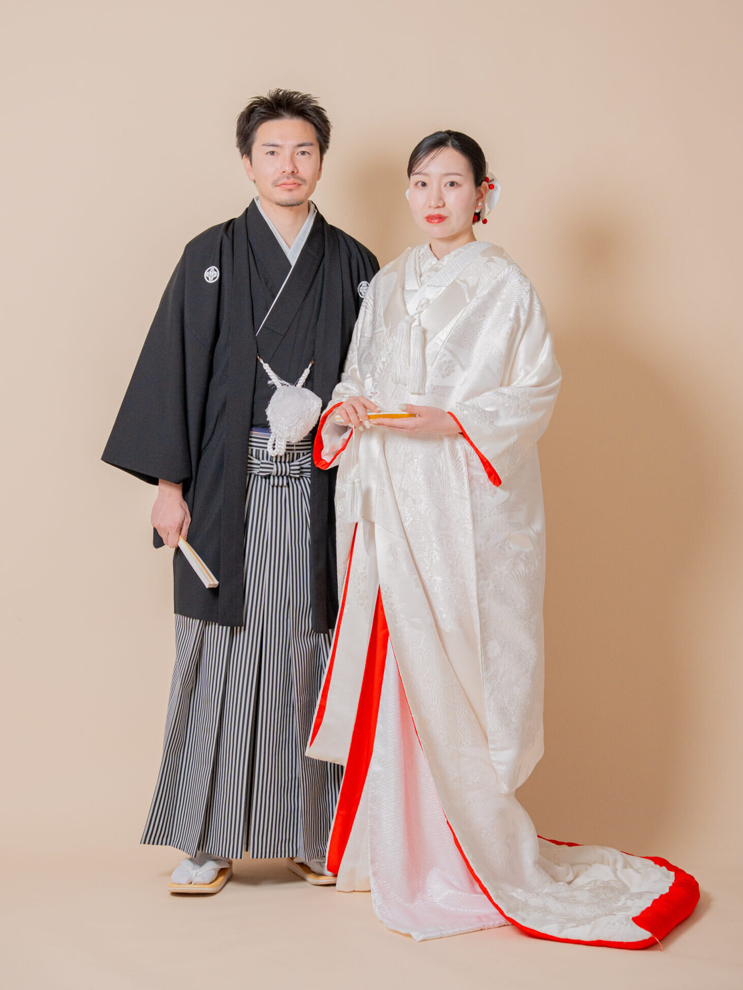 伝統的な黒紋付袴の新郎と赤ふきの白無垢花嫁による、格調高い夫婦の立ち姿