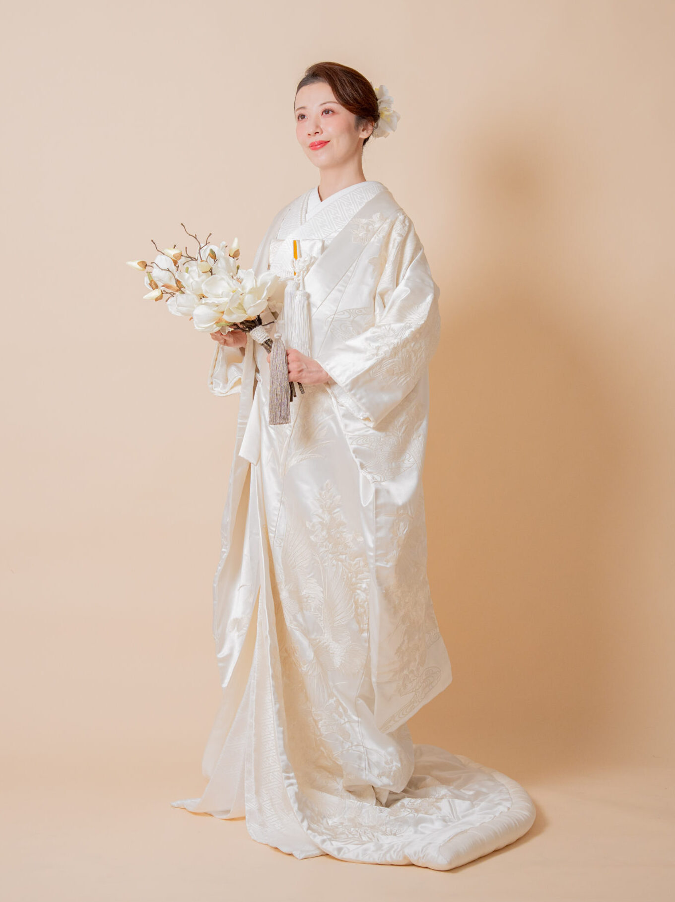 白いブーケを手に持ち、流麗な白無垢を着こなす花嫁の正面ポートレート