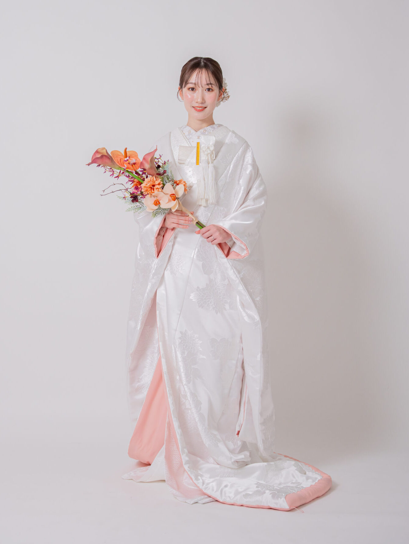 淡い桜色が花嫁の表情を優しく引き立てる、モダンな白無垢の正面ポートレート