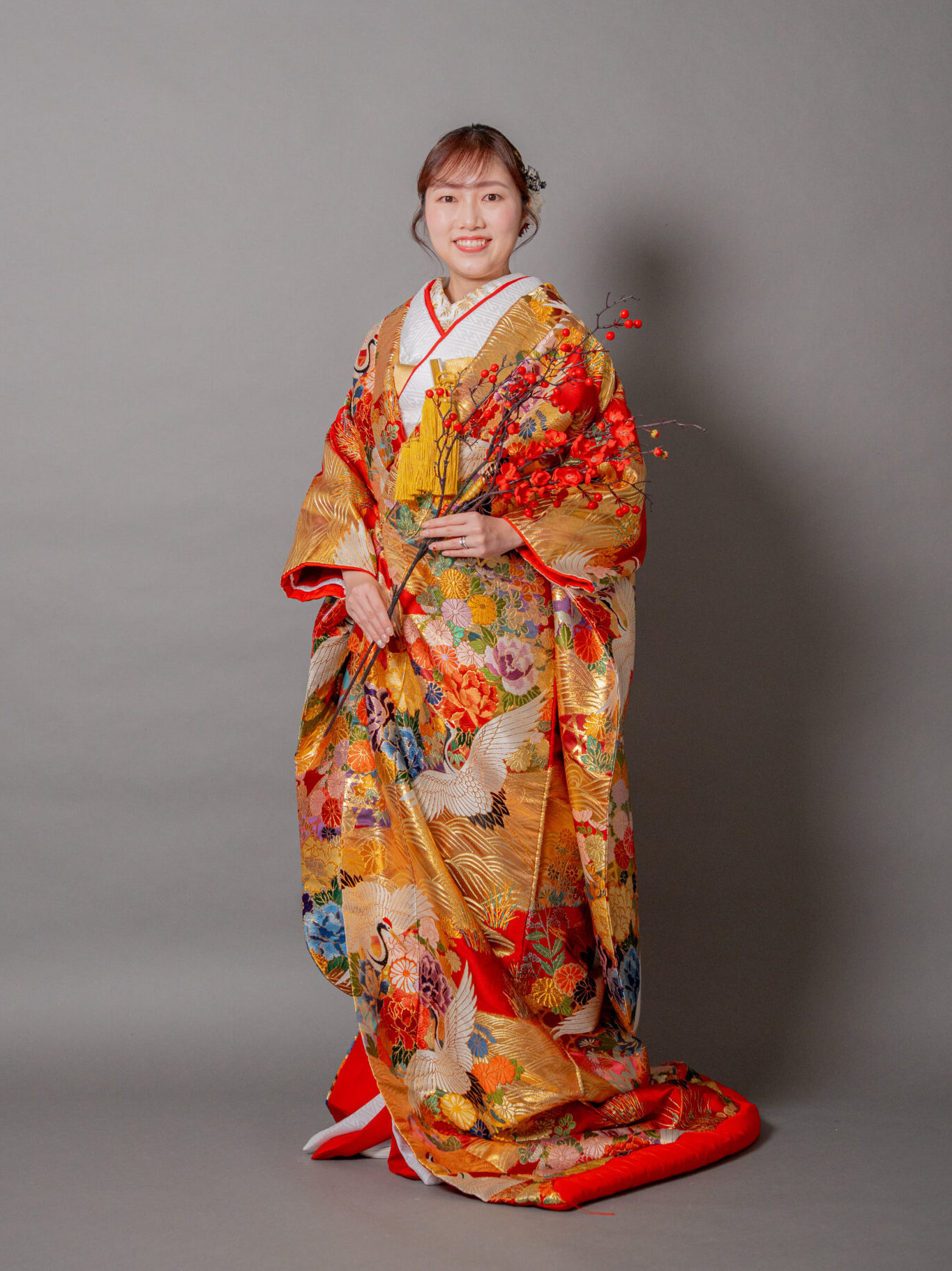赤とゴールドの青海波の色使いが美しい色打掛 手に梅の枝を持った花嫁様ソロショット 大阪和装前撮りスタジオ