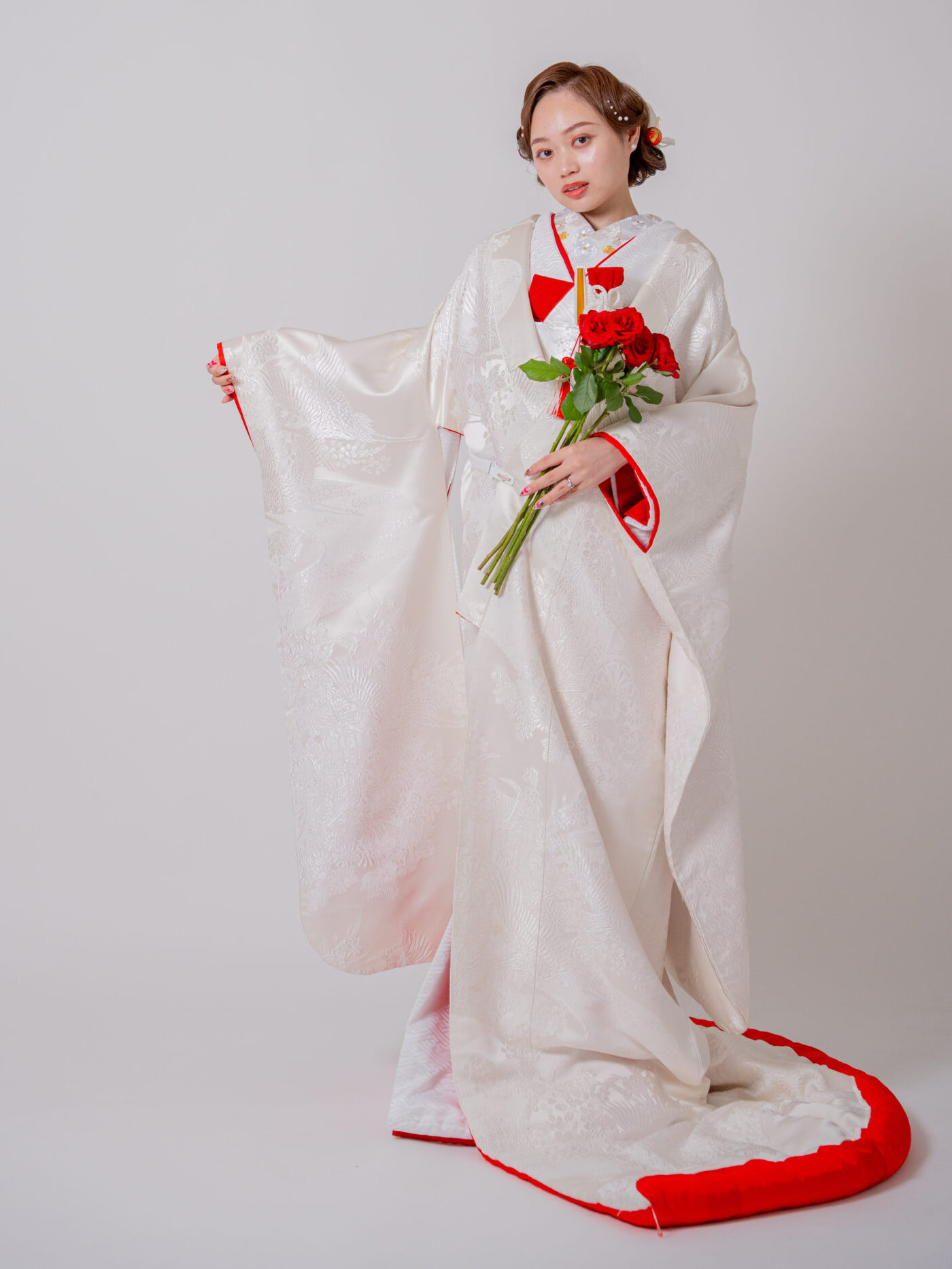 真っ赤な薔薇を手に持ち、紅白のコントラストが際立つ和装花嫁のポートレート