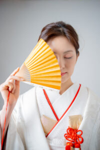 末広で顔を隠した白無垢姿の花嫁様ソロショット