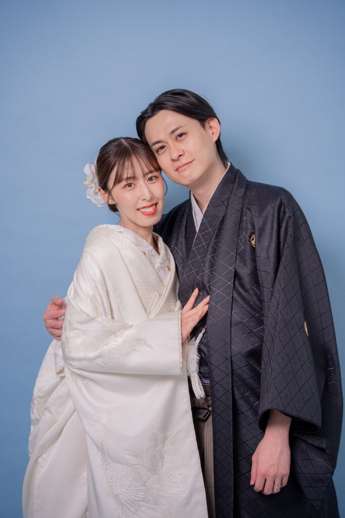 白無垢姿の花嫁と黒紋付き羽織袴の新郎の頬よせ親密ショット