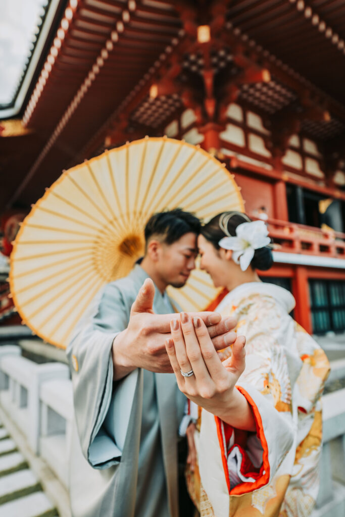 浅草寺でのロケーションフォトを楽しまれる色打掛の花嫁様と色紋付の新郎様の指輪ショット