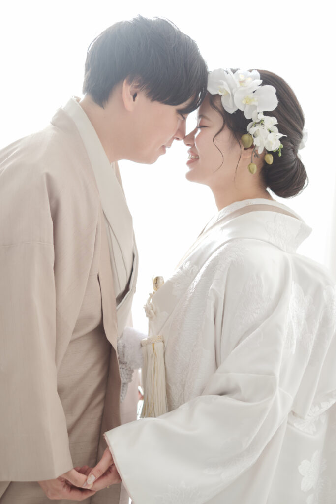 和装専門のスタジオでの鼻をくっつけた白無垢姿の花嫁と色紋付の新郎のポーズ