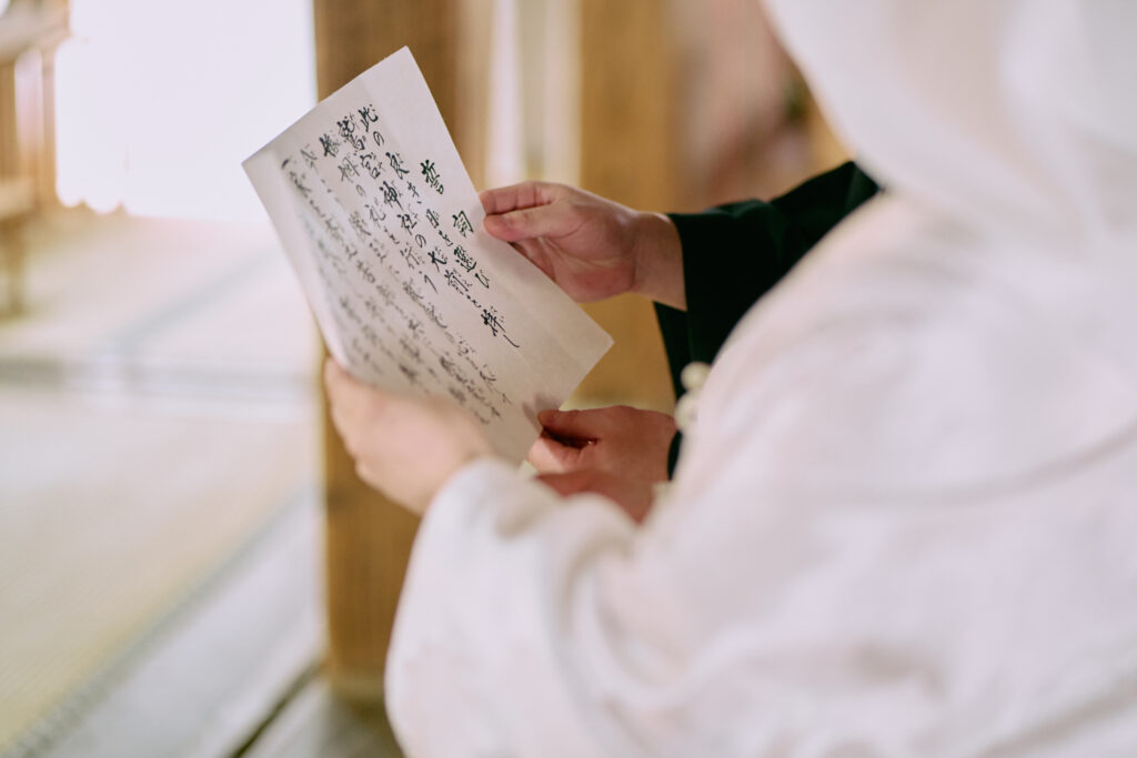 和装結婚式で夫婦の誓いを読み上げる新郎新婦