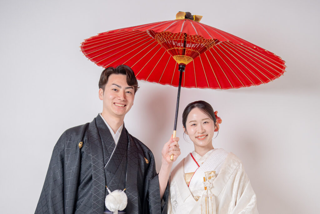 赤色の番傘をもって笑顔で2ショット。
白無垢、横向き