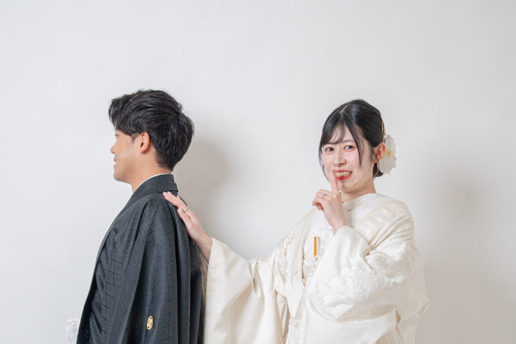 和装でファーストミート。新婦が新郎の肩に手を添えて、シーっと静かに。白無垢