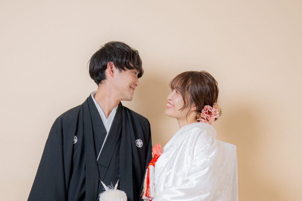 白無垢に赤・ピンクの小物とヘア飾りが際立つショット。ゆるくまとめたヘアスタイルが優しい雰囲気を演出