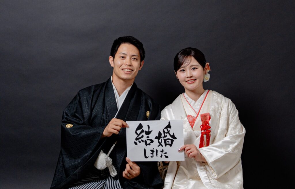 和装姿の新郎新婦が「結婚しました」ショット。紋付き袴、白無垢
