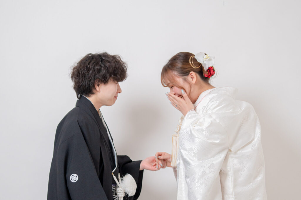 和装姿の新郎新婦が手を取り合い、照れ笑いから始まるファーストミート