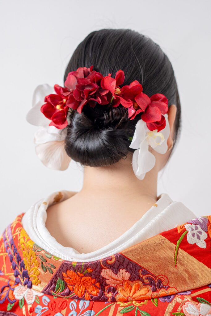 新婦のヘアショット、赤い打掛と同色のお花で華やかに