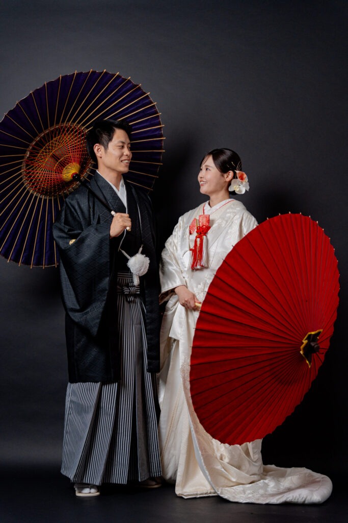 和装の新郎新婦が番傘をもって見つめあう素敵なショット。自然な笑顔