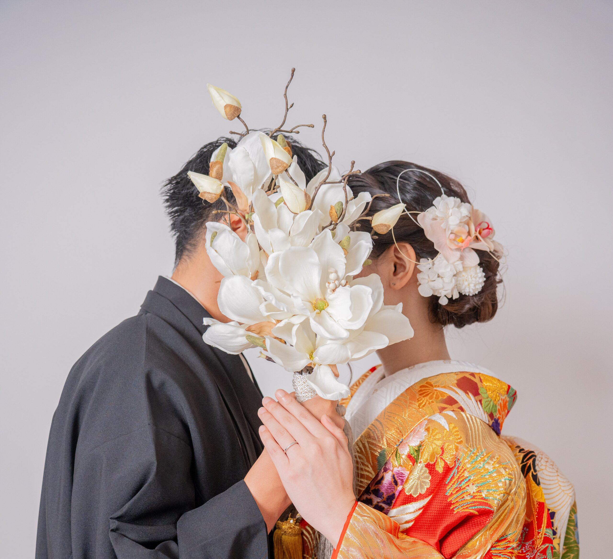 和装の新郎新婦がブーケでお顔を隠したおしゃれショット