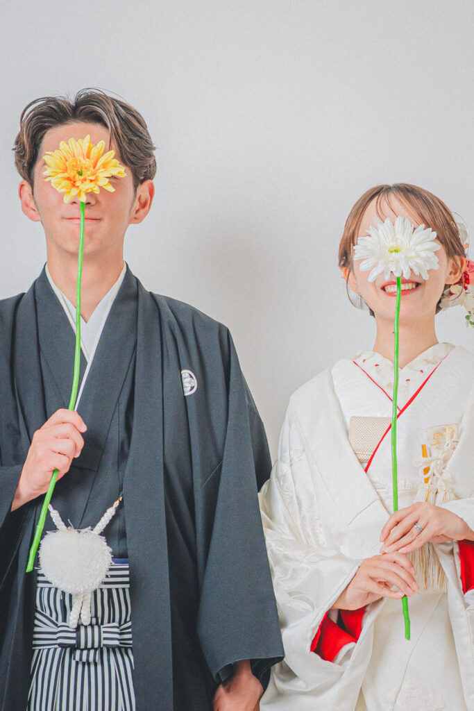 和装の新郎新婦がそれぞれのお花をもったおしゃれなショット。紋付き袴、白無垢