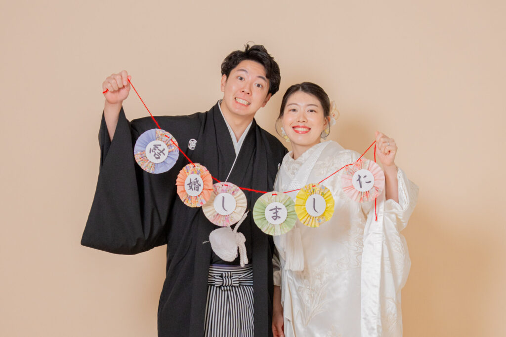 和装の新郎新婦がガーランドをもった笑顔の2ショット