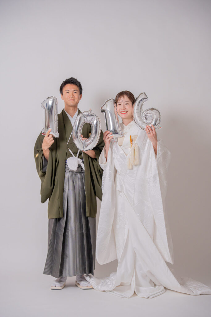 和装の新郎新婦が、記念日の数字のバルーンを持参し、一緒に撮影