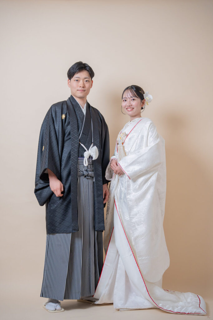 和装の新郎新婦の正面立ち姿王道ショット。紋付き袴、白無垢。