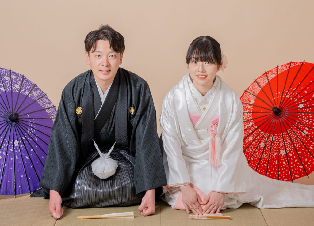 和装の新郎新婦が畳の上で正座ショット。番傘、白無垢、紋付き袴