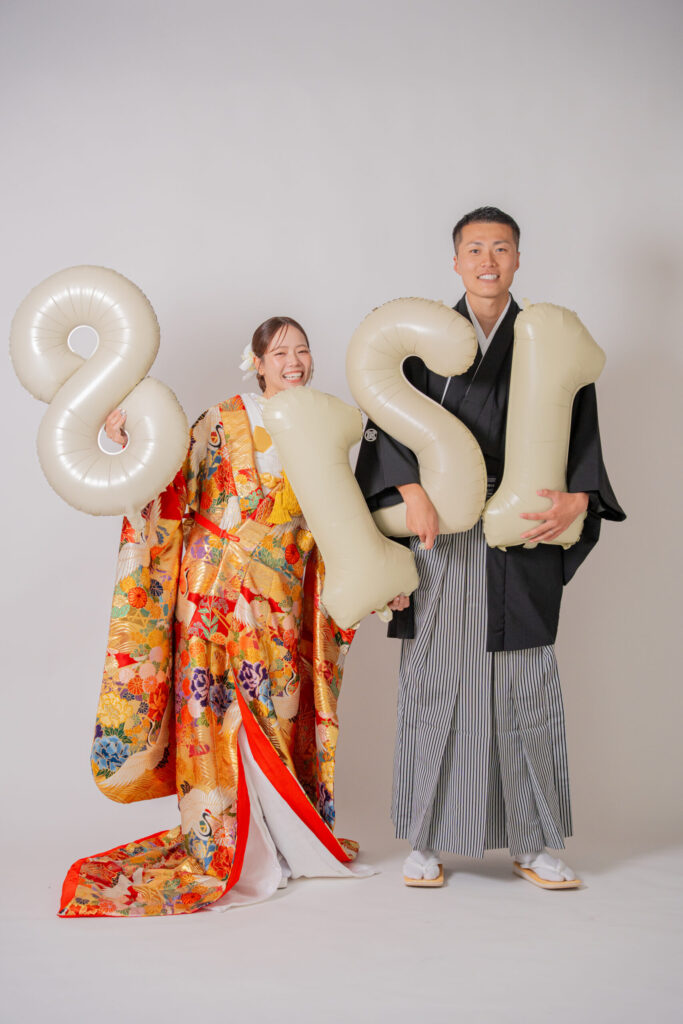和装の新郎新婦が記念日バルーンを持っておしゃれショット。紋付き袴、色打掛。