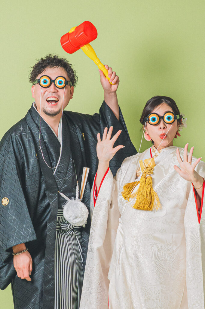 和装の新郎新婦がスタジオの小物で遊ぶおふざけショット。紋付き袴、、白無垢