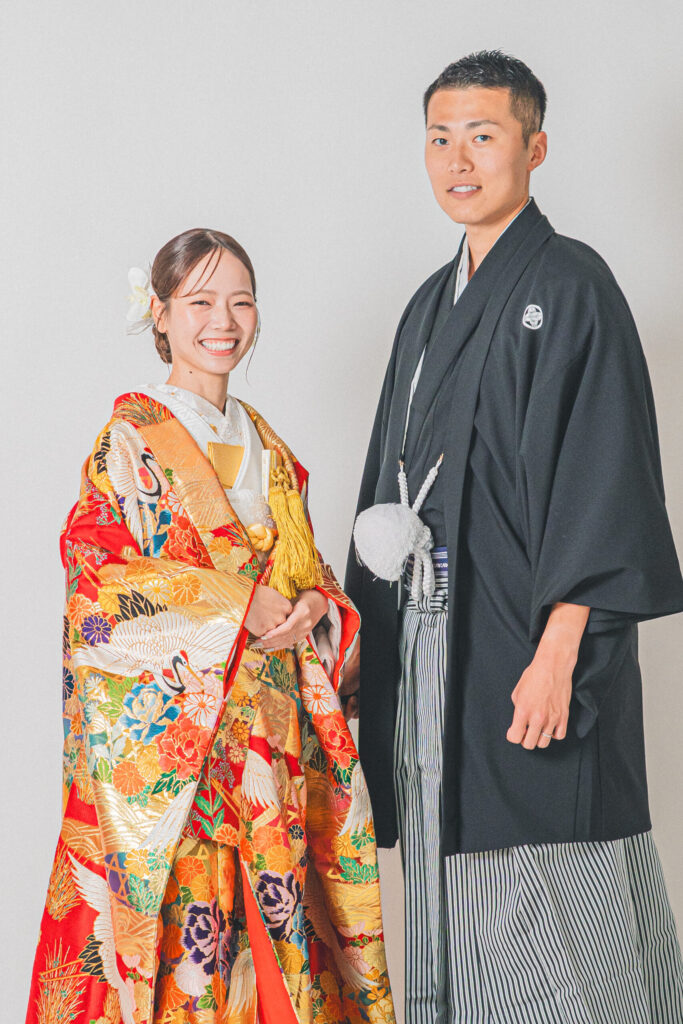 和装の新郎新婦が正面を向いた王道2ショット。紋付き袴、色打掛。