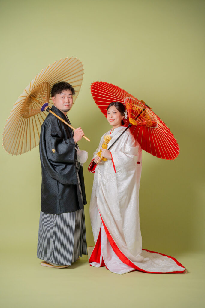 和装の新郎新婦が番傘2ショット。紋付き袴、白無垢