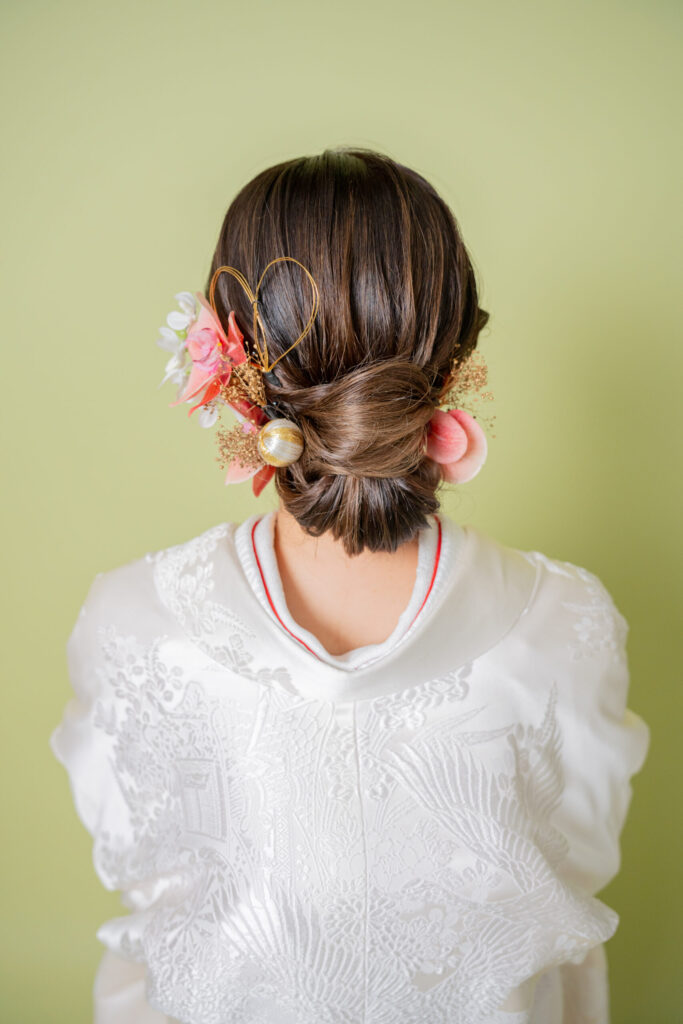 水引をハート型にあしらい、ピンクのお花を合わせたキュートな和装ヘアアレンジ