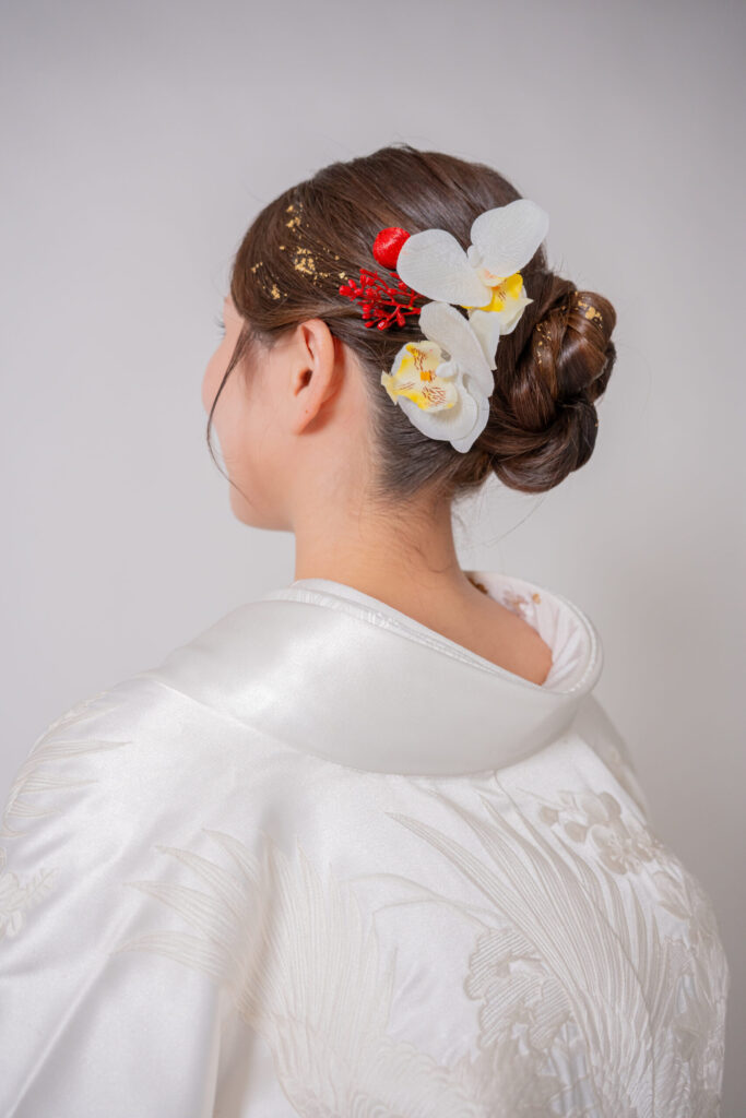 白無垢に似合う胡蝶蘭と金箔、赤い実をあしらった上品な和装ヘアアレンジ