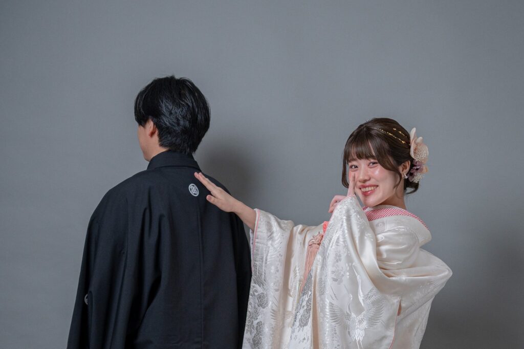 白無垢姿の花嫁が紋付袴の新郎の肩をたたいて振り向かせるファーストミートの瞬間