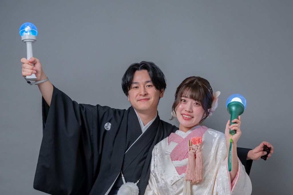 和装の新郎新婦がライブのペンライトを掲げて笑顔を見せる前撮り写真